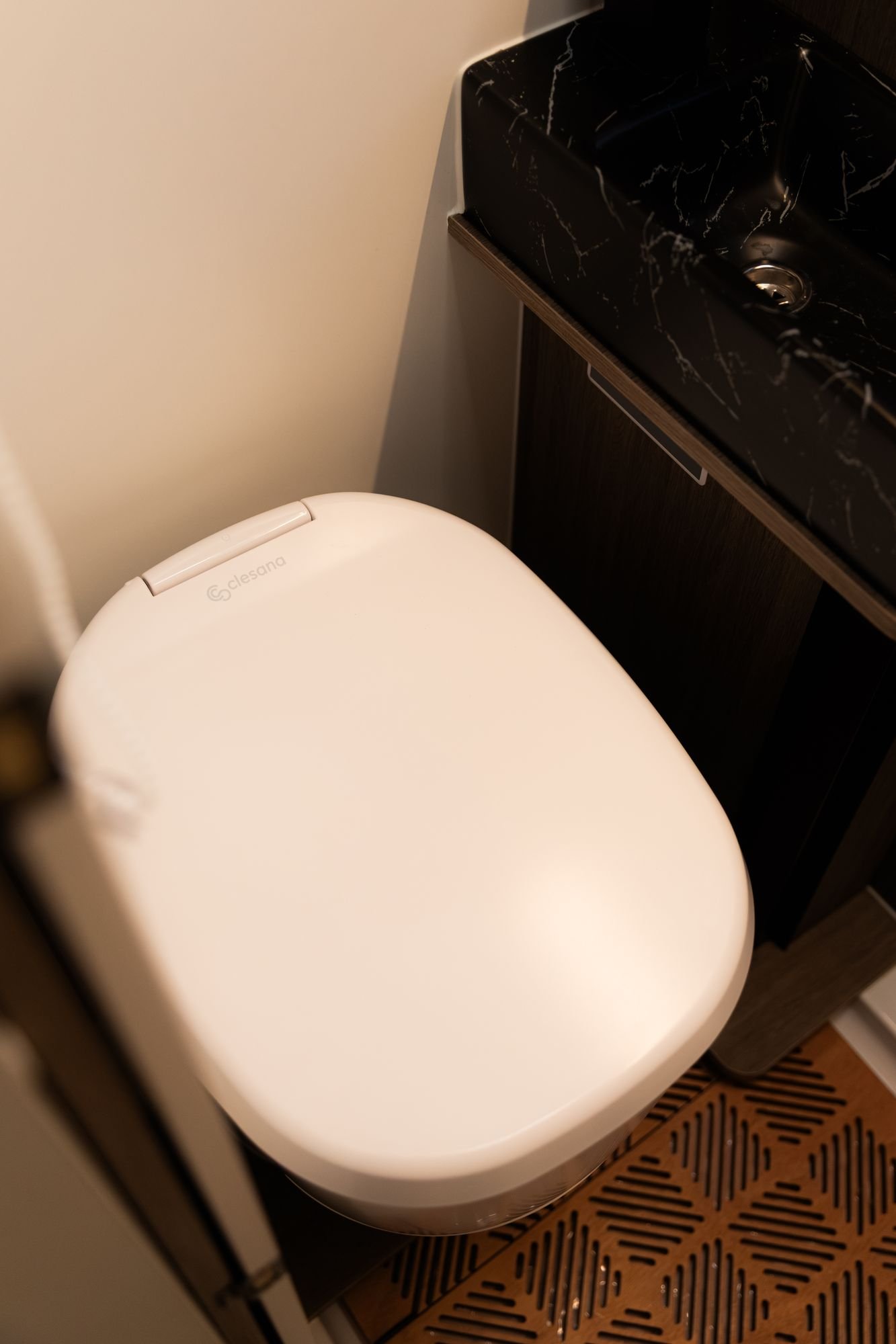 Inodoro y lavabo de mármol negro en el baño de la camper