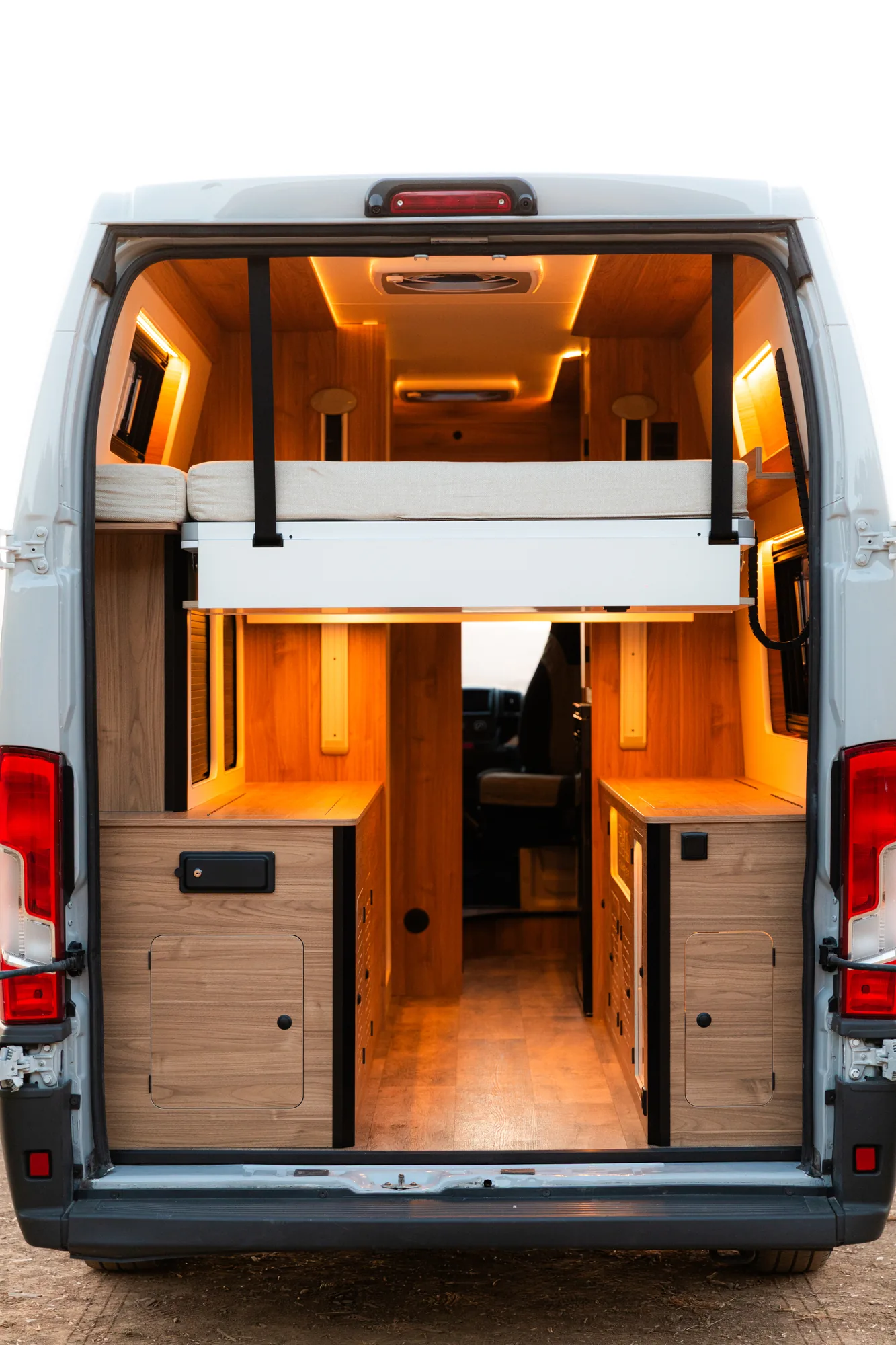 Puertas traseras abiertas de la Citroën Jumper con cama elevable, armarios de madera y pasillo central